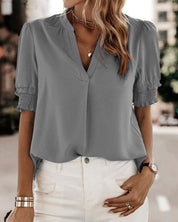 Blouse met een stijlvolle V-hals en trendy korte mouwen. Een veelzijdige aanvulling op je garderobe met een perfecte balans tussen casual en professioneel. Gemaakt van luchtige chiffon en duurzaam polyester voor comfort en stijl. Voorzien van een flatterende V-hals, pofmouwen en een losse pasvorm voor bewegingsvrijheid. Maattabel beschikbaar voor borst, lengte en mouwen.