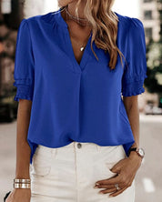 Blouse met een stijlvolle V-hals en trendy korte mouwen. Een veelzijdige aanvulling op je garderobe met een perfecte balans tussen casual en professioneel. Gemaakt van luchtige chiffon en duurzaam polyester voor comfort en stijl. Voorzien van een flatterende V-hals, pofmouwen en een losse pasvorm voor bewegingsvrijheid. Maattabel beschikbaar voor borst, lengte en mouwen.