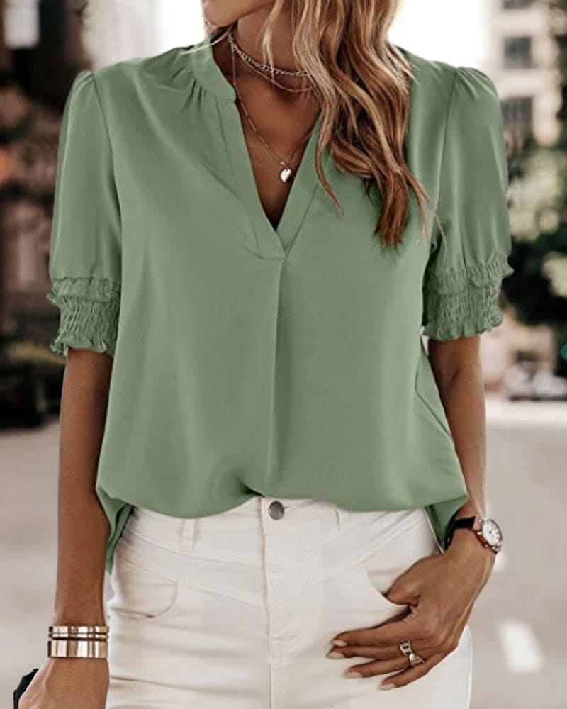 Blouse met een stijlvolle V-hals en trendy korte mouwen. Een veelzijdige aanvulling op je garderobe met een perfecte balans tussen casual en professioneel. Gemaakt van luchtige chiffon en duurzaam polyester voor comfort en stijl. Voorzien van een flatterende V-hals, pofmouwen en een losse pasvorm voor bewegingsvrijheid. Maattabel beschikbaar voor borst, lengte en mouwen.