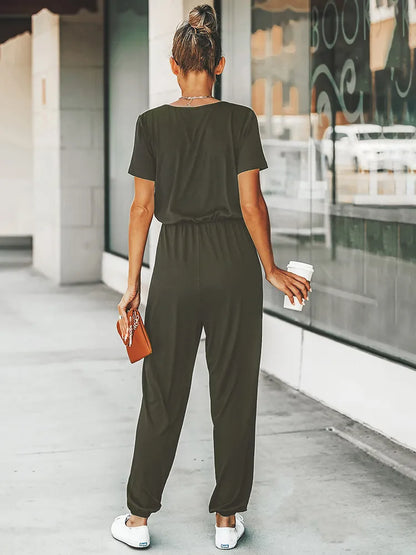 Stijlvolle zwarte jumpsuit met korte mouwen, v-hals en elastische taille voor een trendy uitstraling en comfortabele pasvorm. Gemaakt van polyester en spandex voor een soepele en mooie val over het lichaam. Een must-have voor diverse gelegenheden.