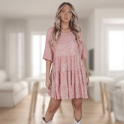 Glinsterende babydoll-casual jurk met lichte en zwierige snit voor bewegingsvrijheid en comfort. Deze jurk is voorzien van korte mouwen, stijlvolle details en is veelzijdig te combineren voor zowel een casual als glamoureuze uitstraling.