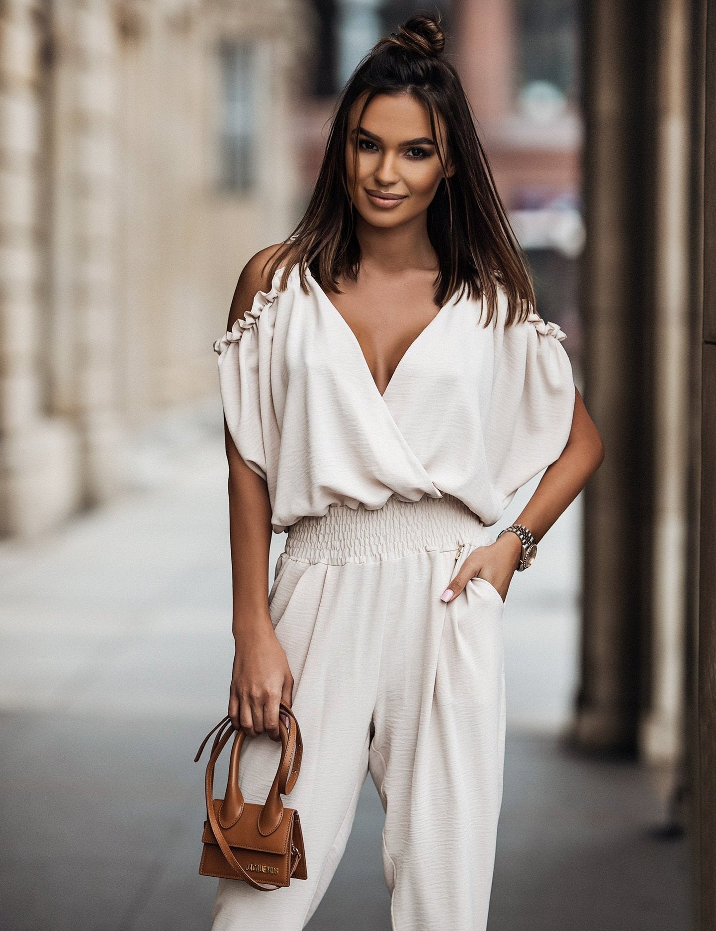 Witte jumpsuit met trendy open schouders, elegante V-hals en comfortabele elastische tailleband. Perfect voor zowel chique als casual looks.